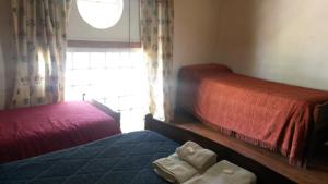 a bedroom with two beds with towels on the bed at Posada Los Balnearios in San Pedro