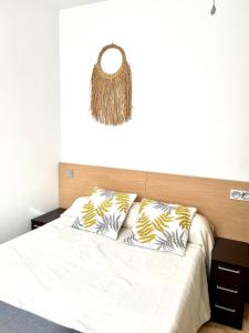 - une chambre avec un lit doté de draps et d'oreillers blancs dans l'établissement Precioso apartamento, à Malaga