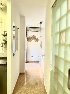 une cuisine aux murs blancs et un couloir dans l'établissement Precioso apartamento, à Malaga