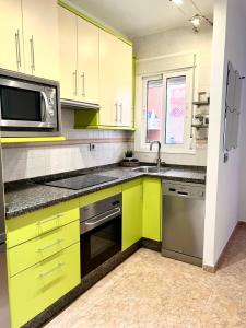 une cuisine avec des armoires jaunes et un four micro-ondes dans l'établissement Precioso apartamento, à Malaga