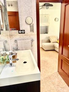 Elle comprend un salon et une salle de bains pourvue d'un lavabo blanc. dans l'établissement Precioso apartamento, à Malaga