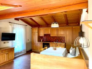 a kitchen with wooden cabinets and a white table at Chalet Forciagn in San Vigilio Di Marebbe
