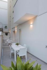 un patio avec des tables blanches, des chaises et des plantes dans l'établissement Residence Armony, à Misano Adriatico