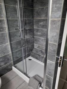 um chuveiro com uma porta de vidro na casa de banho em Bosloe em Helston