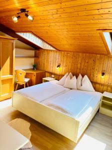 a bedroom with a large bed in a wooden ceiling at Chalet Forciagn in San Vigilio Di Marebbe