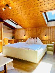 1 dormitorio con cama grande en el techo de madera en Appartamenti Thomas, en San Vigilio Di Marebbe