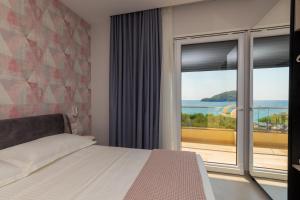 a bedroom with a bed and a view of the ocean at Corallo Rooms in Himare