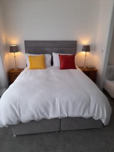 a bedroom with a white bed with four pillows at Bosloe in Helston