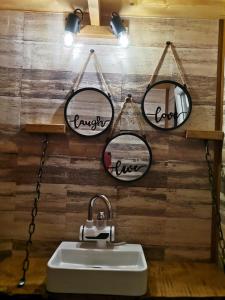 a bathroom with three mirrors and a sink at Cazare la Vama Buzăului - Căsuța Festung in Vama Buzăului
