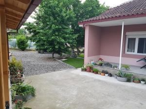 une maison rose avec des plantes dans une cour dans l'établissement M Apartments, Bogorodica, Gevgelija, à Gevgelija