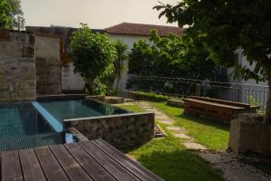 a backyard with a swimming pool and a wooden bench at Casa do Ribeirinho in Amarante