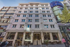 un gran edificio blanco con gente caminando delante de él en Glorious Hotel, en Estambul