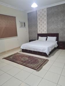 a bedroom with a bed and a rug on the floor at نارين للشقق المفروشة in Taif
