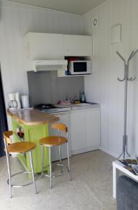 a small kitchen with a table and two chairs at La Halte 1C in Villeret +23 photos