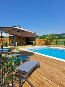 uma piscina com espreguiçadeiras e um guarda-sol em Le Domaine Vesque em Saint-Pierre-de-Clairac