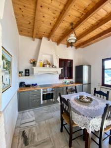 Il comprend une cuisine avec une table et des chaises ainsi qu'une cuisine dotée de plafonds en bois. dans l'établissement Stonehouse villas with breathtaking view, à Siteía