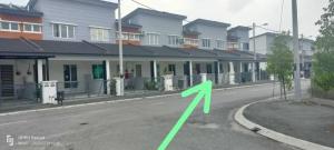 a green arrow on a road in front of houses at Raihan Homestay Seri Iskandar Perak Near UTP UITM in Seri Iskandar