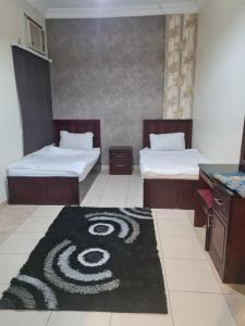 a bedroom with two beds and a carpet with a spiral at نارين للشقق المفروشة in Taif