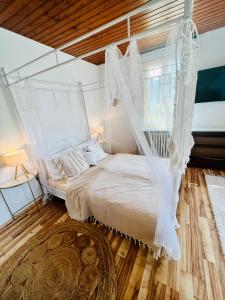 ein Schlafzimmer mit einem weißen Bett mit Baldachin in der Unterkunft Cloud 9 , Apartment mit Garage und Garten in Nähe der Uniklinik, Bosch, Ina Schaeffler in Homburg