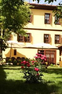 une maison avec des fleurs roses dans la cour dans l'établissement SARI KONAK Garden Otel Safranbolu, à Safranbolu