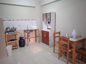 uma cozinha com uma mesa e uma cadeira num quarto em La casa de Chepita em Cusco