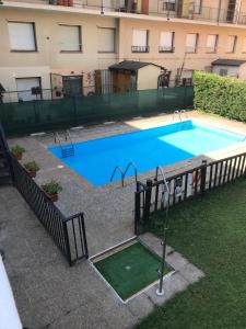 une grande piscine bleue en face d'un bâtiment dans l'établissement Hostal Casa Juan, à Castejón de Sos