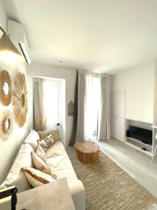 a white living room with a couch and a table at Beach House Old Town in Cascais