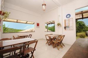a dining room with tables and chairs and windows at pousada CASA 29 BÚZIOS in Búzios