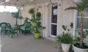 a patio with potted plants and a table and chairs at iMama' Rooms in Pachino