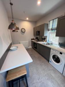 a kitchen with a sink and a washing machine at Sparkling Space - Twin or King Beds in Bangor