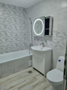 een badkamer met een wastafel, een bad en een toilet bij Luxurious apartment with 3 rooms and 2 bathrooms in Corabia in Corabia