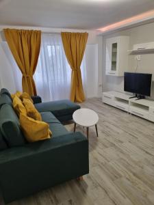 a living room with a couch and a tv at Luxurious apartment with 3 rooms and 2 bathrooms in Corabia in Corabia