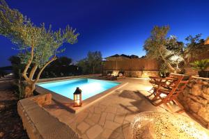 una piscina in un cortile di notte di AURAS - Glamping Eco Resort a Biograd na Moru