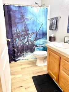 a bathroom with a shower curtain with a ship on it at Yosemite Escapes - Pine Mountain Lake in Groveland +12 photos