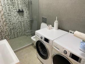 La salle de bains est pourvue d'un lave-linge et d'un sèche-linge. dans l'établissement OrAnge villa, à Gonio