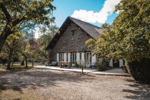 a stone house with a large yard in front of it at La Petite Auberge in Bédouès