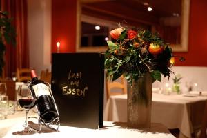 a bottle of wine and a vase of flowers on a table at Hotel Brienz in Brienz