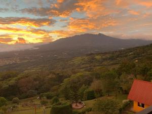 a view of a valley with trees and a sunset at Cabañas El Parador in Boquete