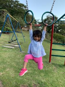 a little girl is playing on a swing at Cabañas El Parador in Boquete