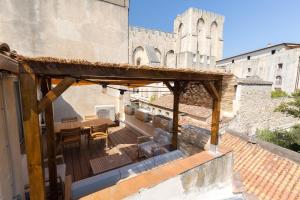 een patio met een tafel en stoelen in een gebouw bij La Terrasse du Palais in Avignon