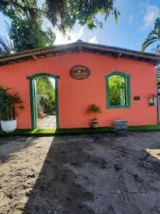 a house with an orange wall at Cantinho da Cineka in Caraíva