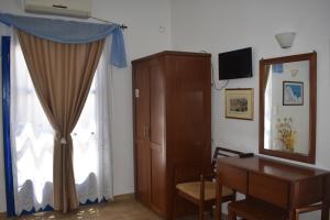 a living room with a desk and a window at Aegean Star Hotel in Karavostasi