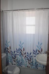 a bathroom with a shower curtain with a toilet and a sink at Aegean Star Hotel in Karavostasi