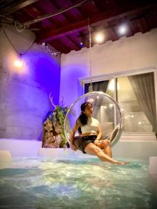 a woman sitting in a hoop in a swimming pool at 墾丁 Sky Villa 工業風設計 包棟民宿 in Eluan