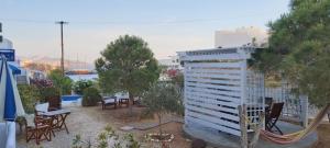 a building with chairs and a hammock in a yard at Aegean Star Hotel in Karavostasi