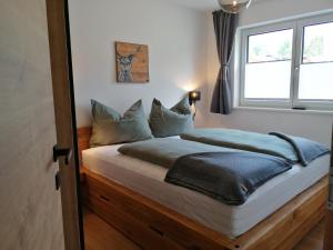 a bedroom with a bed with a window at Das Prinzenberg Appartement in Maria Alm am Steinernen Meer