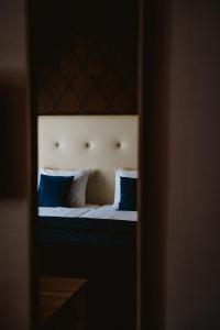 a bedroom with a bed with blue pillows at Hotel Brasserie Florian in Wijk bij Duurstede