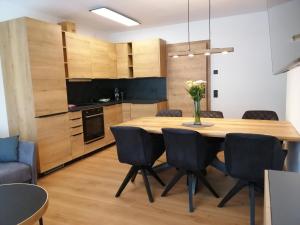Das Prinzenberg Appartement في ماريا ألم آم شتاينرنين مير: مطبخ وغرفة طعام مع طاولة وكراسي خشبية