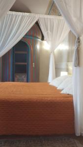 a bedroom with a large bed and a large window at Riad Puchka in Marrakesh