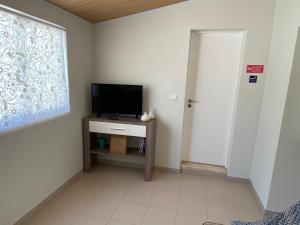 a room with a television on a table with a window at Casa Ameixa in Alcobaça